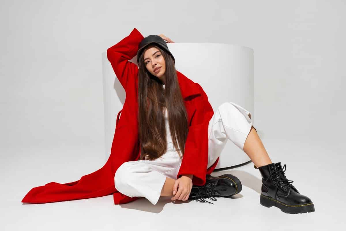 fashionable-model-stylish-hat-red-coat-boots-posing-white-wall-studio-1.jpg