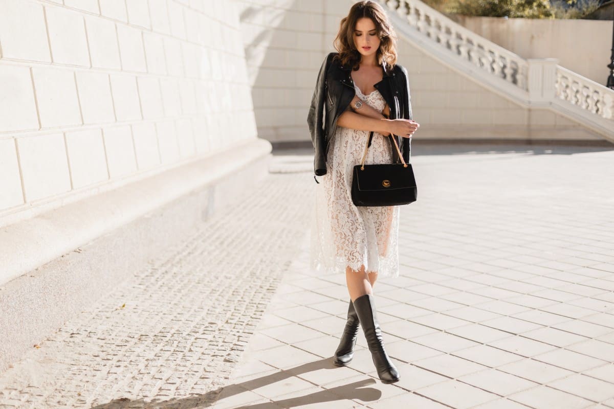 young-stylish-woman-walking-street-fashionable-outfit-holding-purse-wearing-black-leather-jacket-white-lace-dress-spring-autumn-style-posing-high-leather-boots-1.jpg